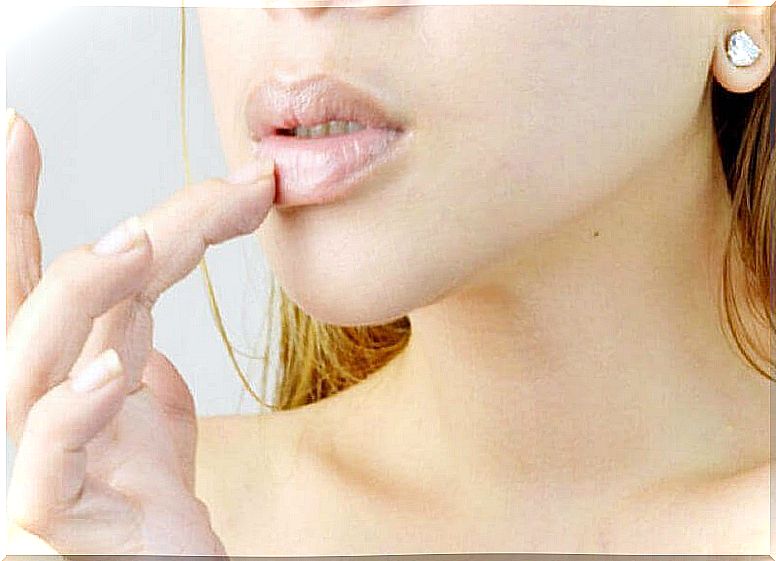 Woman feels with finger on her dry lips